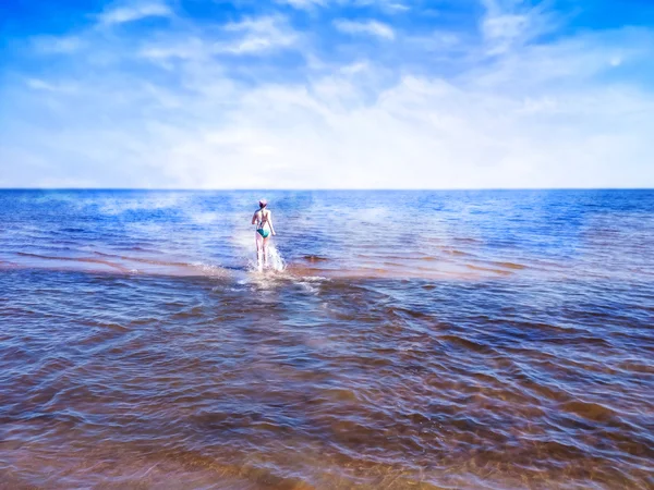 Menina bonita correndo na água brilhante do mar azul — Fotografia de Stock