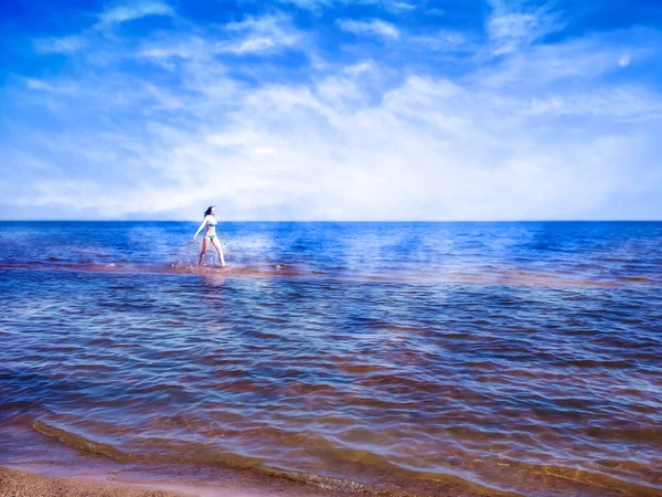 Menina bonita correndo na água brilhante do mar azul — Fotografia de Stock