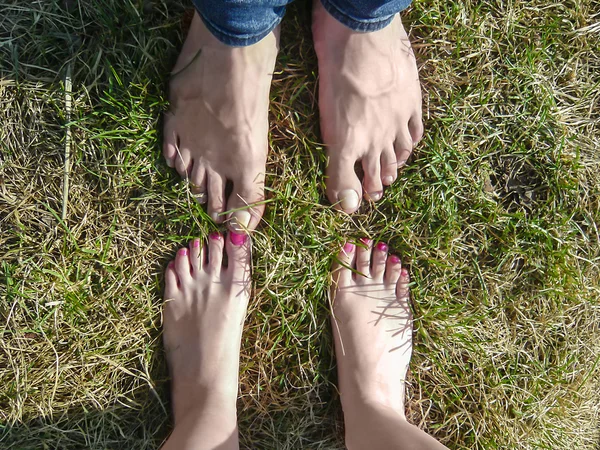 Bare feet of loving couple standing close to each other