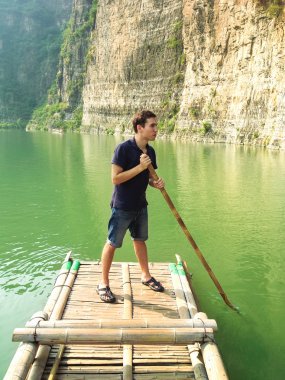 Adam bir bambu Sal üzerinde yüzen
