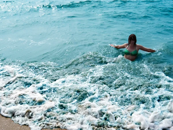 Menina rindo bonita em ondas espumantes de mar azul — Fotografia de Stock