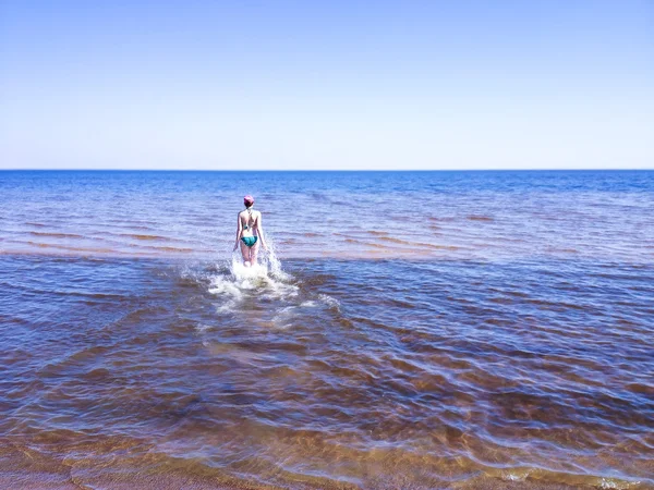 Piękna młoda kobieta chodząca po przezroczystej wodzie — Zdjęcie stockowe