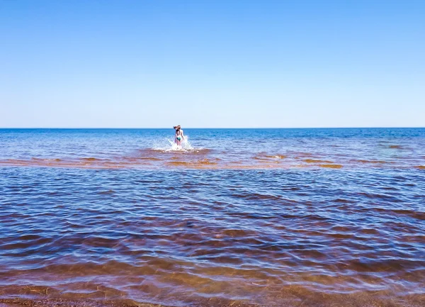 Schöne junge Frau läuft auf transparentem Wasser — Stockfoto