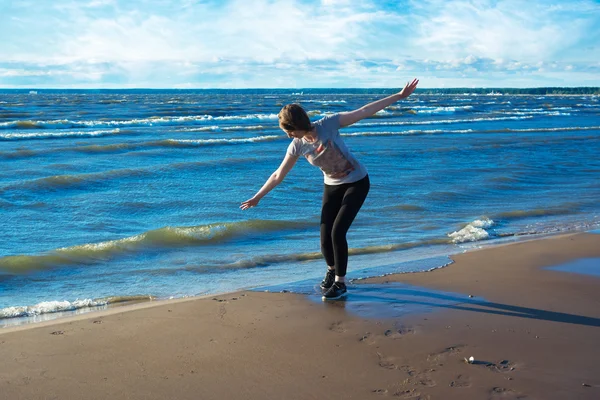 Joyeux jeune femme debout sur la plage — Photo