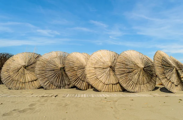 Dřevěné slunečníky na písecné pláže — Stock fotografie