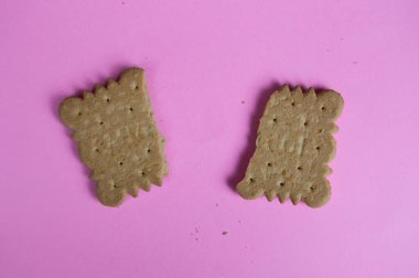 Pembe arka planda kırık bir kurabiye.