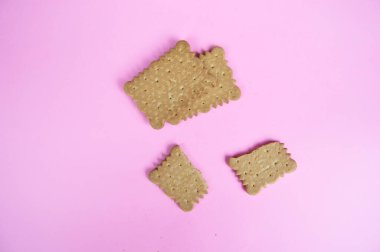 Pembe arka planda kırık bir kurabiye.