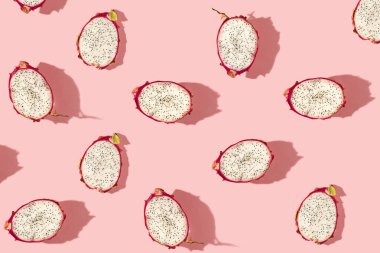 Taze egzotik ejderha meyvelerinden yaratılan desen, pastel pembe arka planda. Üst görünüm.