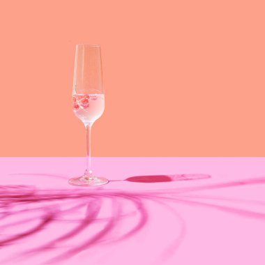 Frenk üzümlü bir bardak kokteyl. Terracotta 'ya karşı düzenleme ve gölgeli açık mor arkaplan.