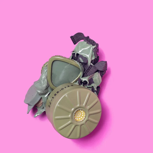 溶融損傷した軍用ガスマスクで作られた環境問題の概念 紫を基調としたアレンジメント — ストック写真