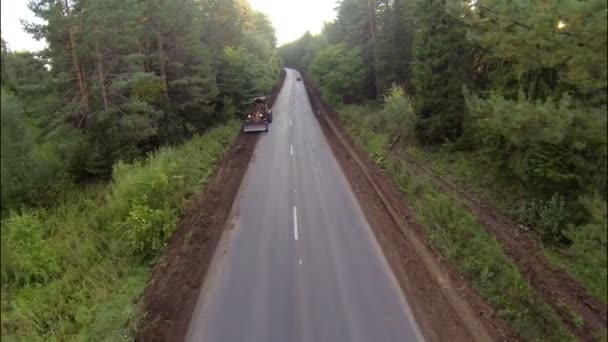 Niveleuse sur la route dans les bois, vue aérienne — Video
