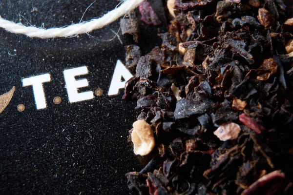 On the table are tea and tea leaves in dark colors top view — Stock Photo, Image