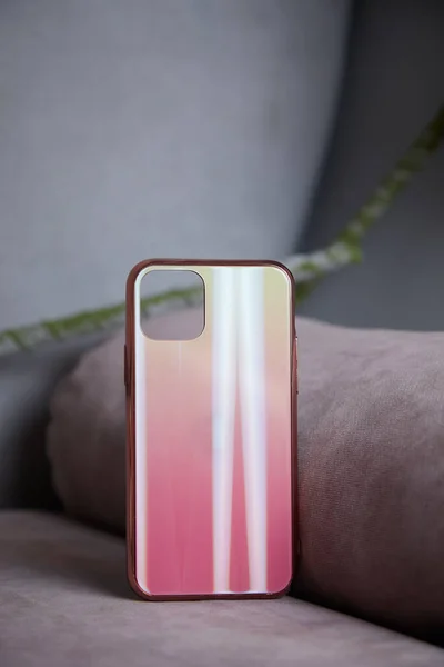 Yapay çiçeklerin arka planında güzel kadınların cep telefonu kılıfları parıldıyor.