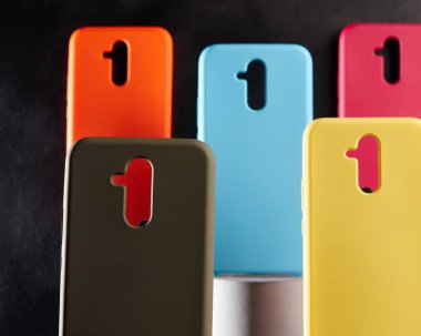 Modern akıllı telefonlar için renkli davalar masanın üzerinde duruyor odak noktası bulanık arka planda bir nesne