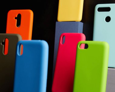 Modern akıllı telefonlar için renkli davalar masanın üzerinde duruyor odak noktası bulanık arka planda bir nesne