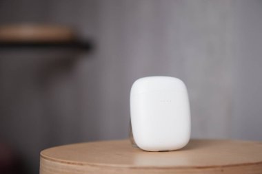 Kablosuz kulaklık çantası masanın üstünde kulaklıkların kapalı kapağı ise bulanık.