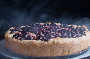 Kirazlı turtalı pasta taze buharlı bir kase içinde üzümlü üzümlü krema ve bir dilim sıcak arka plan bulanıklaşır