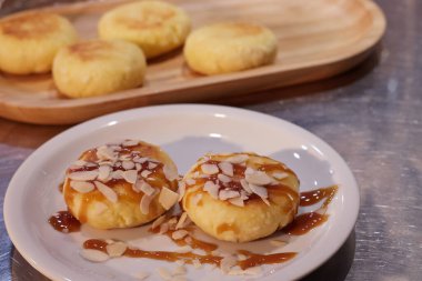 Hazır kızarmış peynirli kekler bir tabakta masanın üzerindeki tepside uzanıyorlar. Arka plan bulanık.