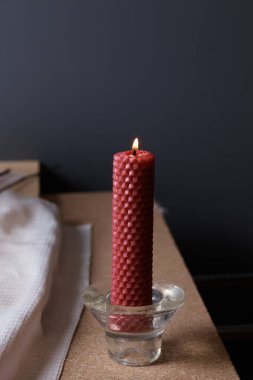 Masadaki cam şamdanda uzun mum yakmak, bulanık arka plan.