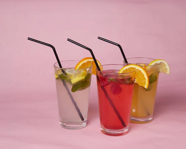 On the table, soft drinks, various cocktails, a glass with a straw and a slice of lemon, a blurred background — Stock Photo, Image