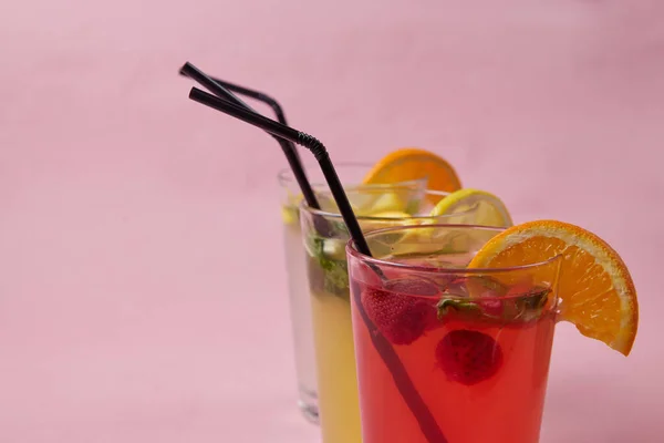 На столе, безалкогольные напитки, различные коктейли, стакан с соломинкой и ломтиком лимона, размытый фон — стоковое фото