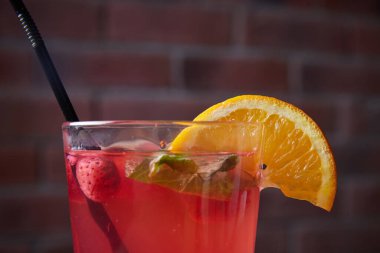 Masada, meşrubatlar, çeşitli kokteyller, kamışlı bir bardak ve bir dilim limon, bulanık bir arka plan.