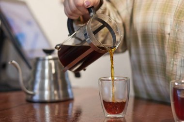 Kahve yapma süreci, doğal bir kahve içeceği filtreden geçirilir ve bir fincana dökülür.