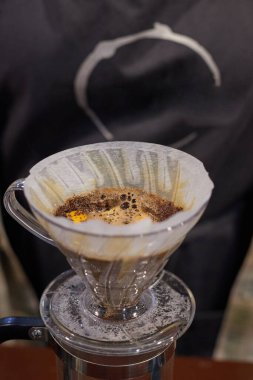 Kahve yapma süreci, doğal bir kahve içeceği filtreden geçirilir ve bir fincana dökülür.