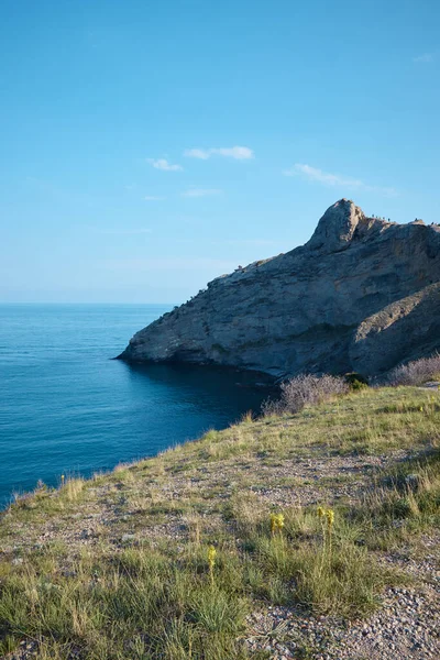 Denizde kayalık kıyı, vahşi sahil ve dağlar, kayalar suya, deniz manzarasına, vahşi doğaya gider.