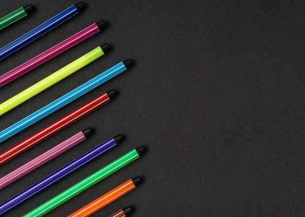 Pattern of the colorful pen on black background. Flat lay. Copy space.