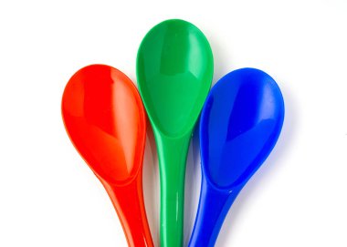 Beyaz arkaplanda izole edilmiş plastik spatulasının kırmızı, yeşil ve mavi rengi.