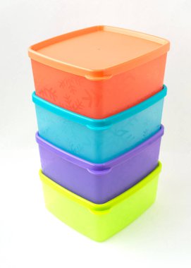 Beyaz arkaplanda izole edilmiş renkli plastik konteyner yığını.