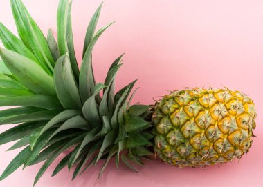 Açık pembe arka planda bir ananas.
