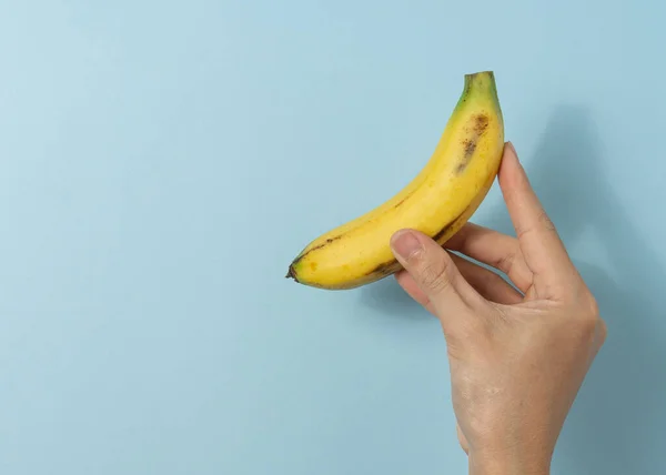 Hand a man holds banana with a copy space.