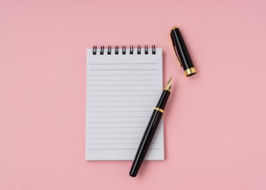 Kopya alanı olan bir defter ve kalem. Düz görünüm.