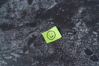 Gülen emojili bir kağıt parçası.