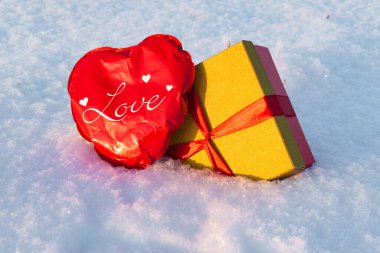Sevgililer günü için karın üstünde kalp ve hediye kutusu..