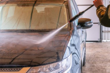 Karcher 'la araba yıkama. Adam siyah arabayı yıkıyor..