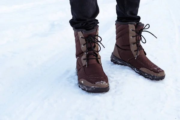Winter brown men\'s boots on the snow.