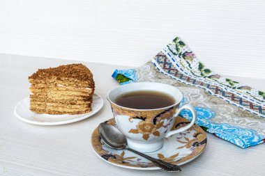 Altın bardak çay hazır. Bir dilim ballı kek.