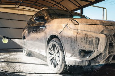 Araba yıkama. Koyu renk bir arabaya şampuan sürüyorum..