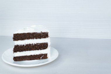 Tereyağı kremalı çikolatalı kek dilimi sol tarafta..