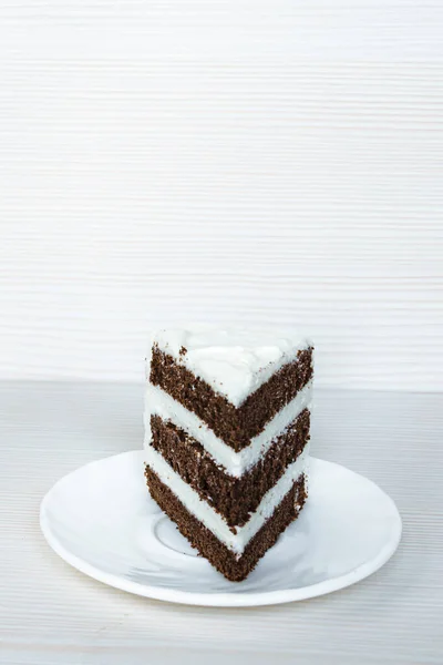 A chocolate sponge cake with butter cream is located in the middle. White background. Vertical photography.