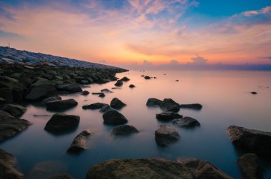 Okyanusu sütlü görünümlü su ile yakın yosunlu rock güneş doğarken
