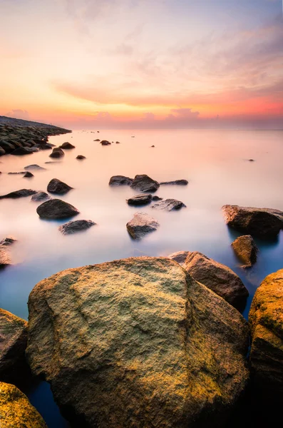 Okyanusu sütlü görünümlü su ile yakın yosunlu rock güneş doğarken