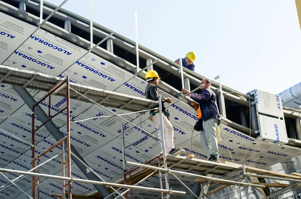 Trabalhador estrangeiro que trabalha na instalação do telhado Imagem De Stock