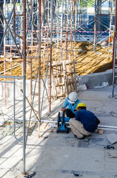 Foreign workers cutting construction material — Stock Photo, Image