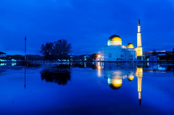 Mavi saat güneş doğarken yansıması ile yüzen cami.