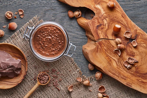 Ahşap arka plan üzerinde yayılmış fındık Cam Kavanoz