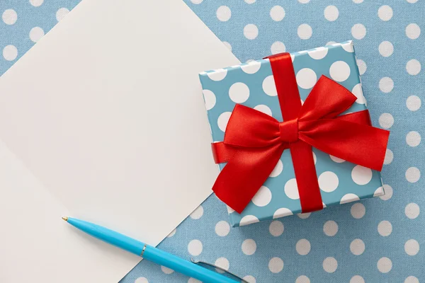 Boîte cadeau à pois, stylo bleu et carte de vœux — Photo
